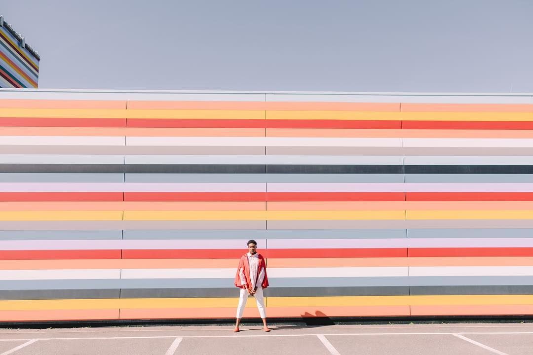 a man standing in front of a colorful wall