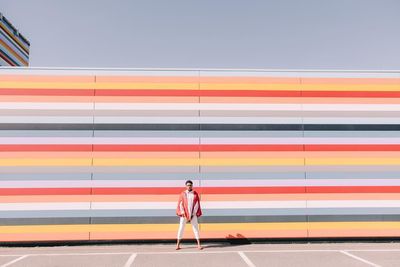 a man standing in front of a colorful wall