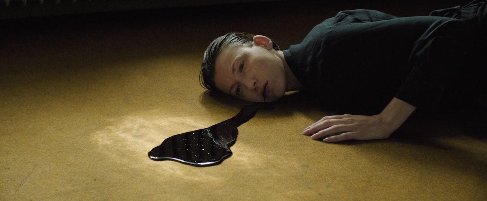 a man laying on the floor with his head on a brush