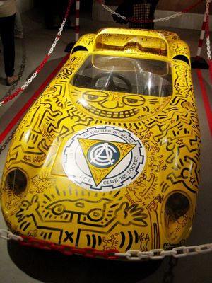 a yellow race car is on display in a museum