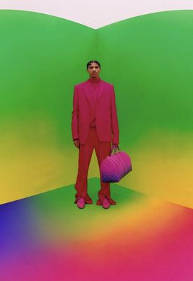 a man in a pink suit holding a purple bag