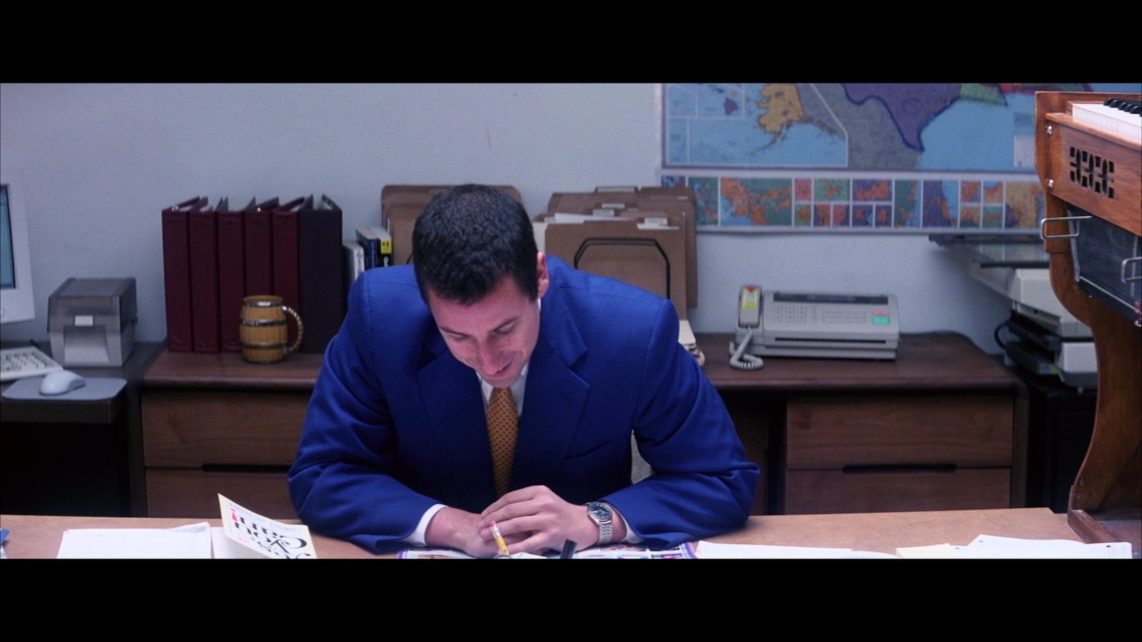 a man in a blue suit writing on a piece of paper