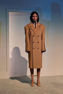 a woman standing in front of a white wall