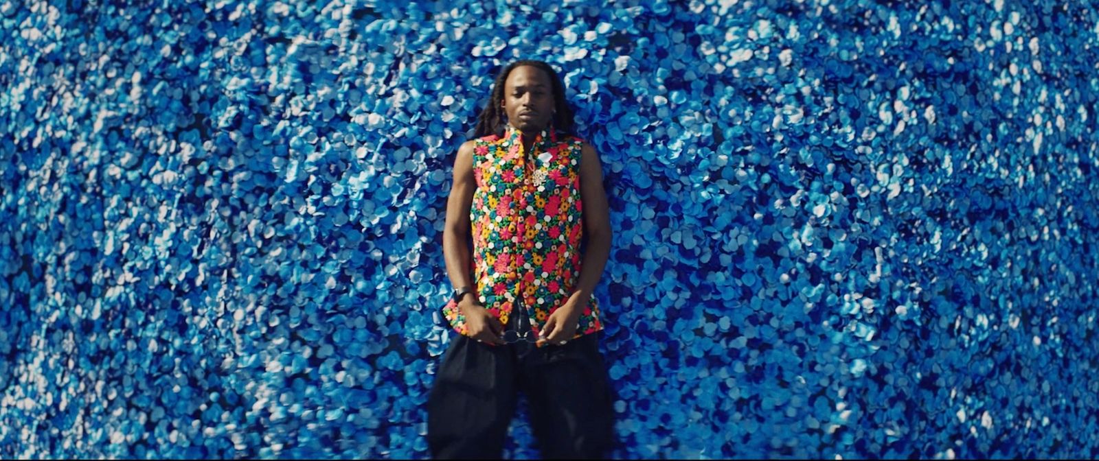 a man standing in front of a blue wall