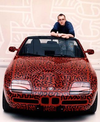 a man sitting on top of a red car