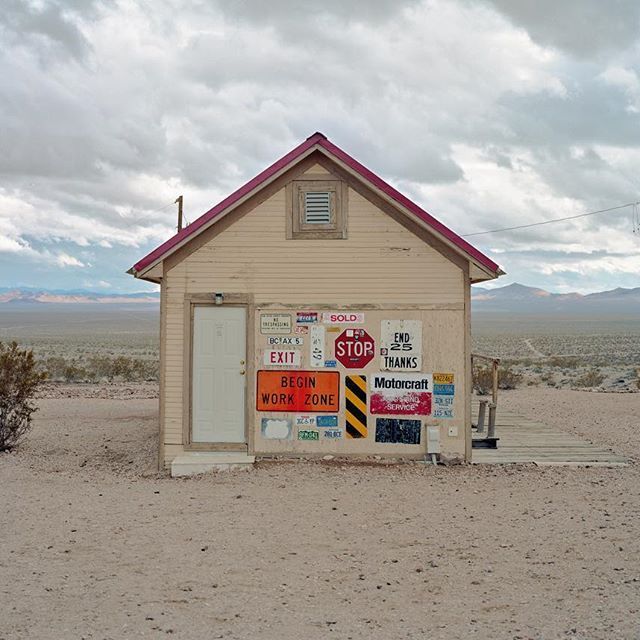 a small building in the middle of a desert