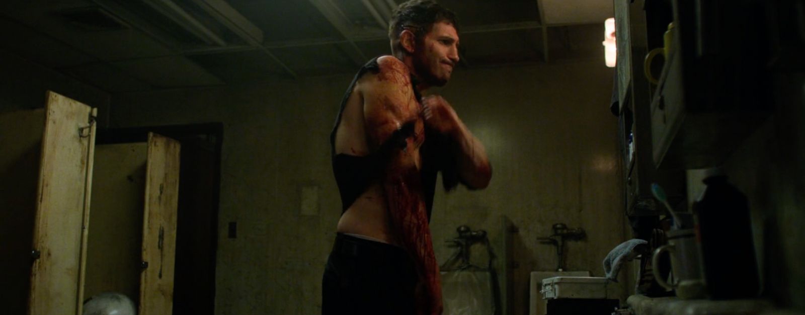 a man standing in a room with a bloody body