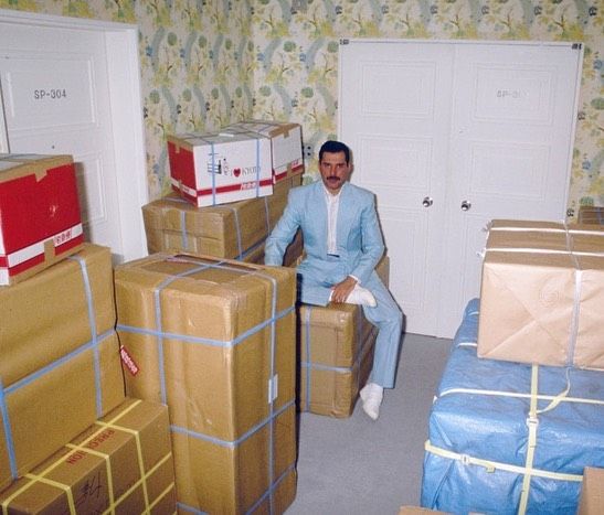 a man sitting on a pile of boxes in a room
