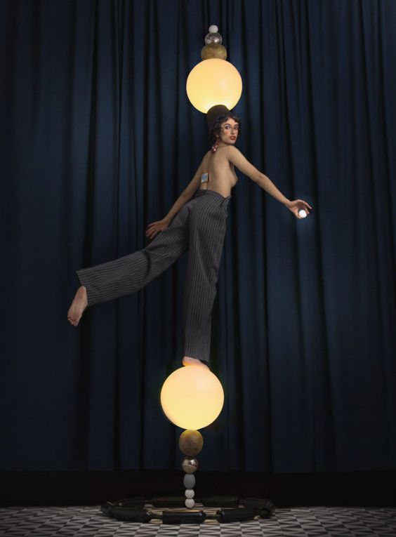 a woman standing on top of a table next to a lamp