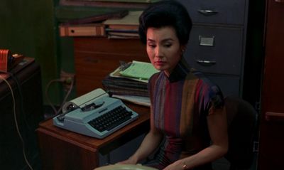 a woman sitting at a desk with a typewriter