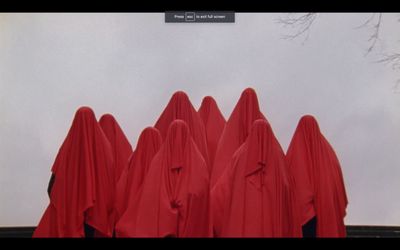 a group of red cloths standing in front of a white wall