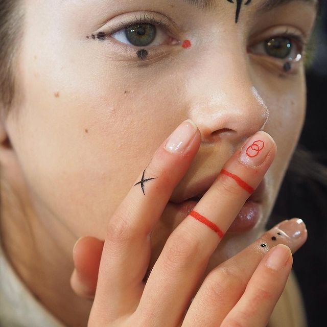 a woman with a cross painted on her nose