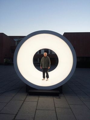 a man standing in front of a large white object