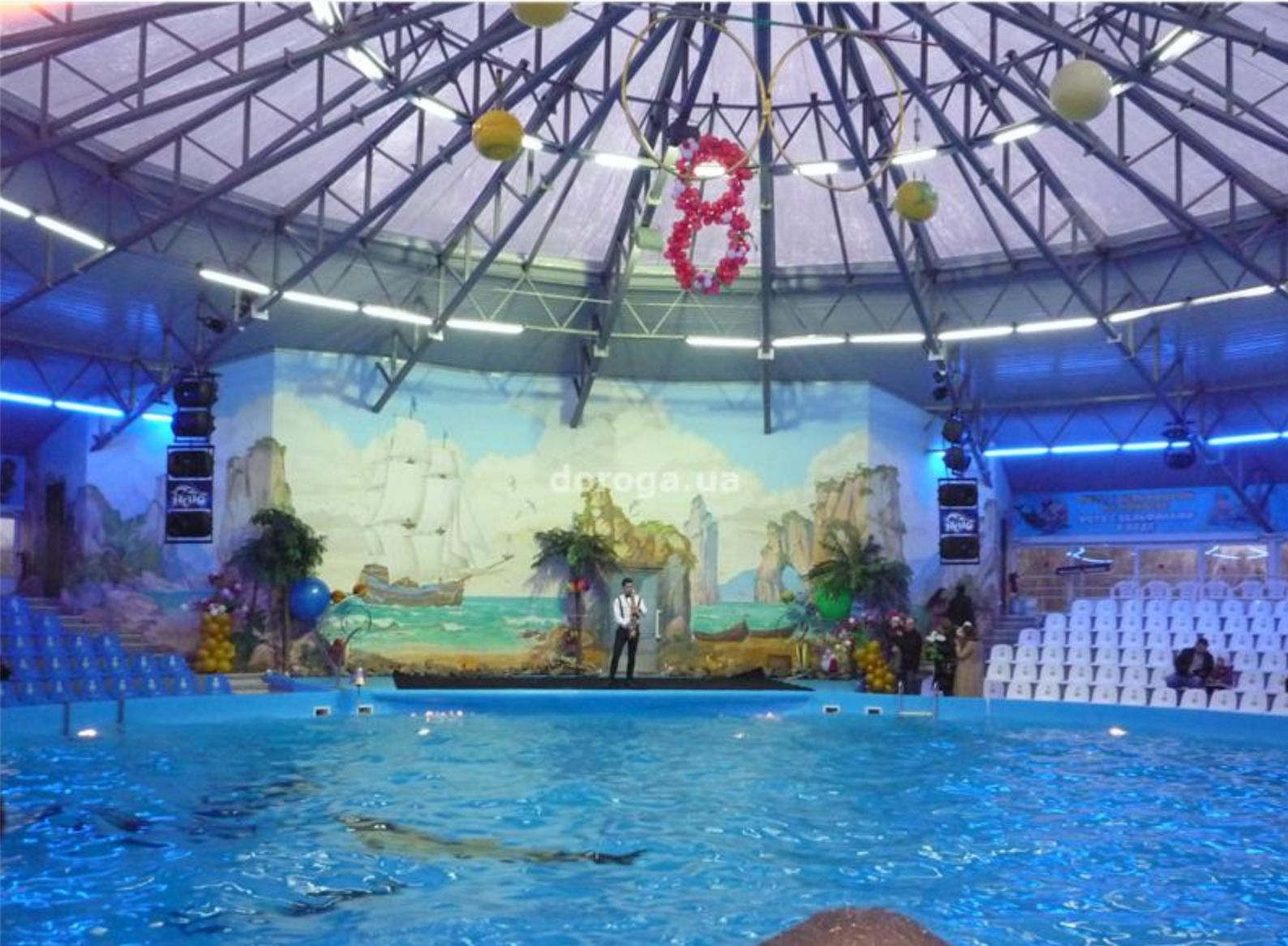 a large indoor swimming pool with a mural on the wall