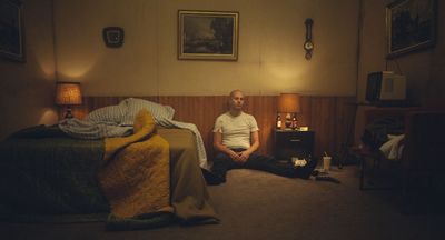 a man sitting on a bed in a room