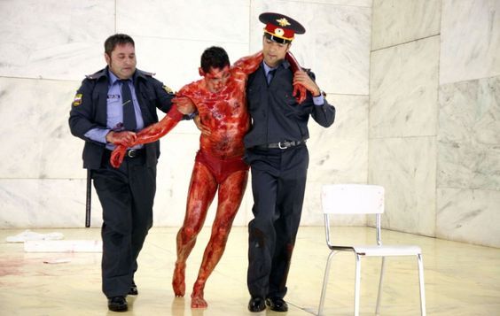 a man in a body paint suit is being escorted by two police officers