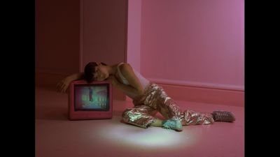 a woman laying on the floor next to a tv