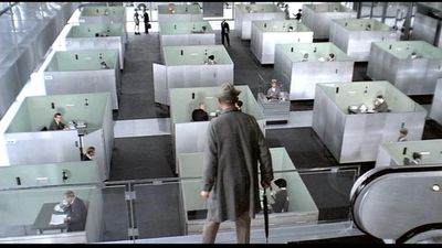 a man standing in a room filled with cubicles