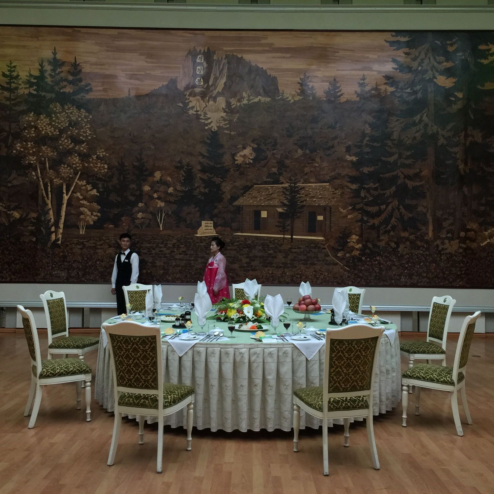 a man and a woman standing in front of a painting