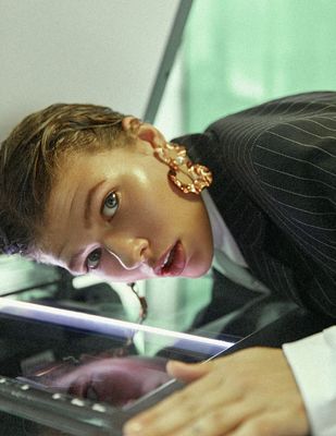 a young man in a suit and tie looking at a cell phone