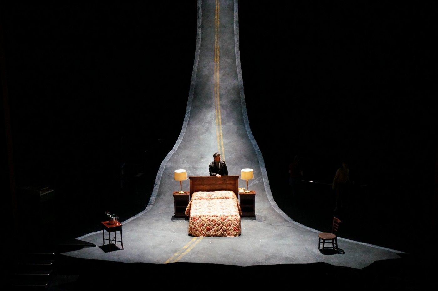 a person sitting on a bed in a dark room