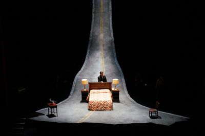 a person sitting on a bed in a dark room