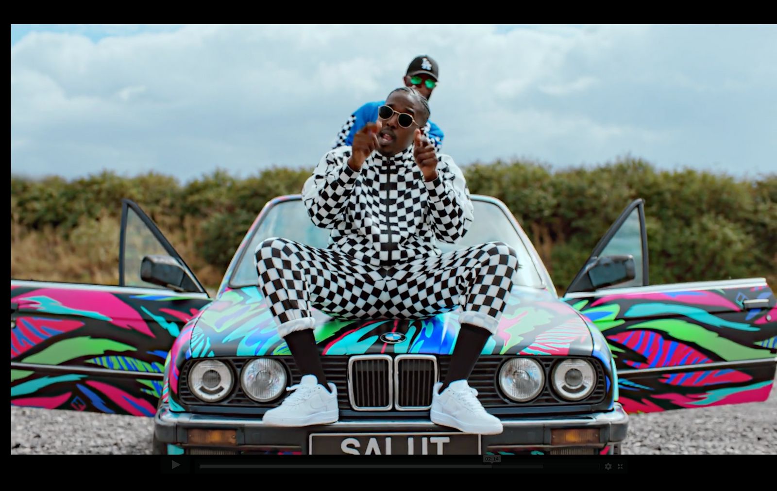 a man sitting on the hood of a car