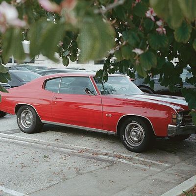 a red car is parked in a parking lot