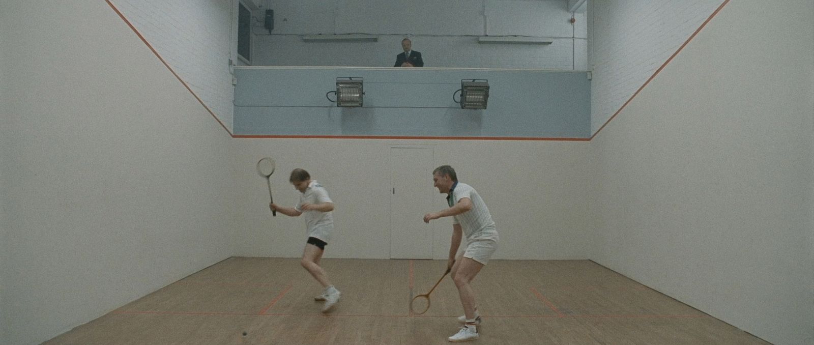 a couple of men standing on top of a tennis court holding racquets