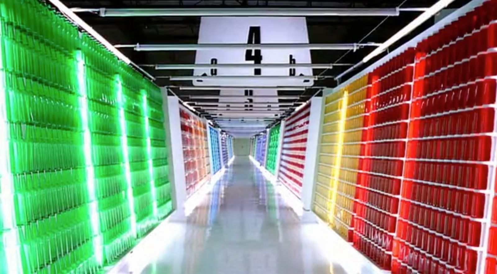 a long hallway with rows of red, yellow, and green servers