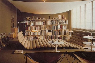 a room filled with lots of books and furniture