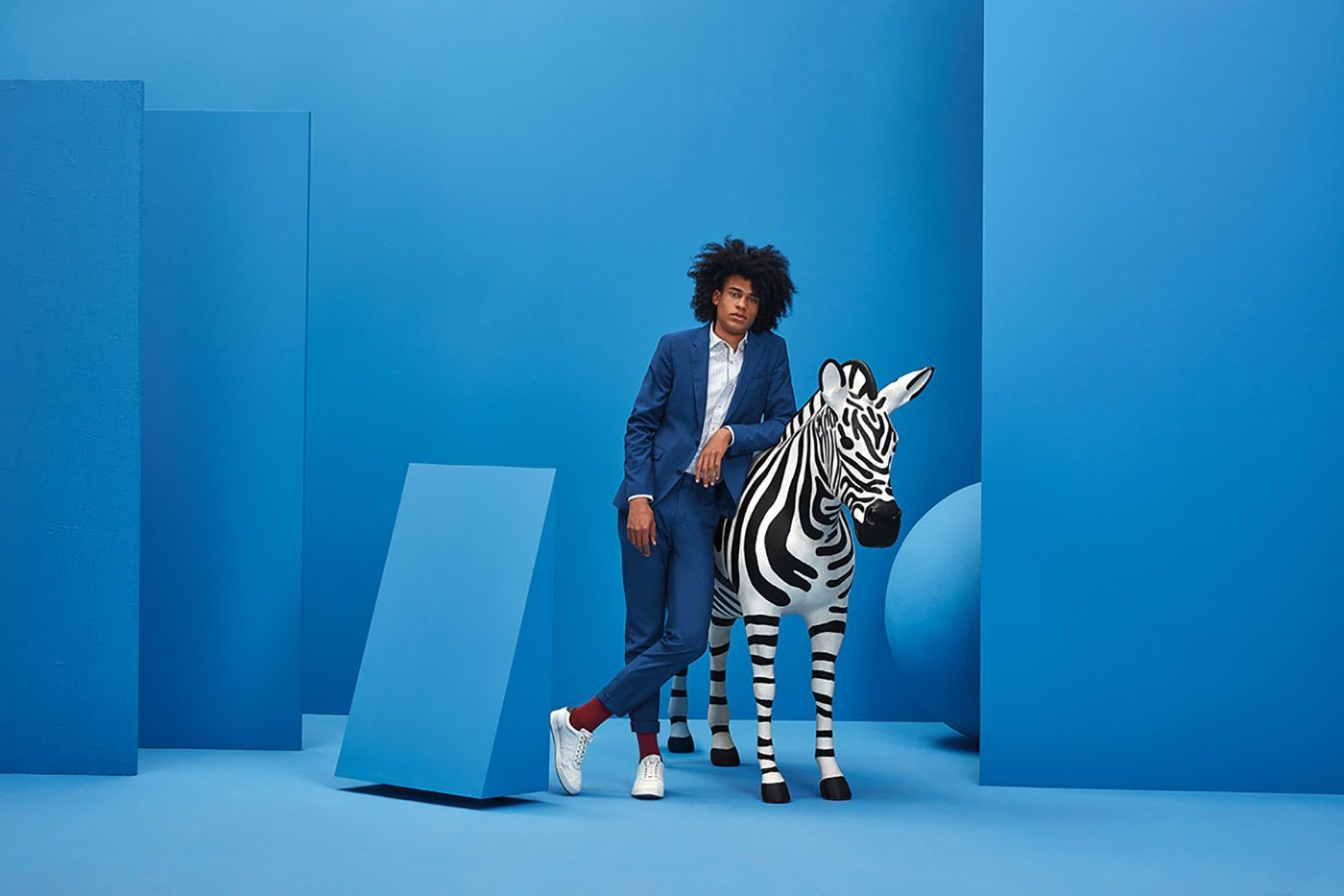 a woman standing next to a zebra in a blue room