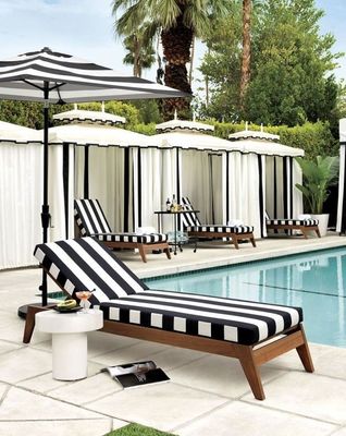 a black and white striped chaise lounge next to a pool