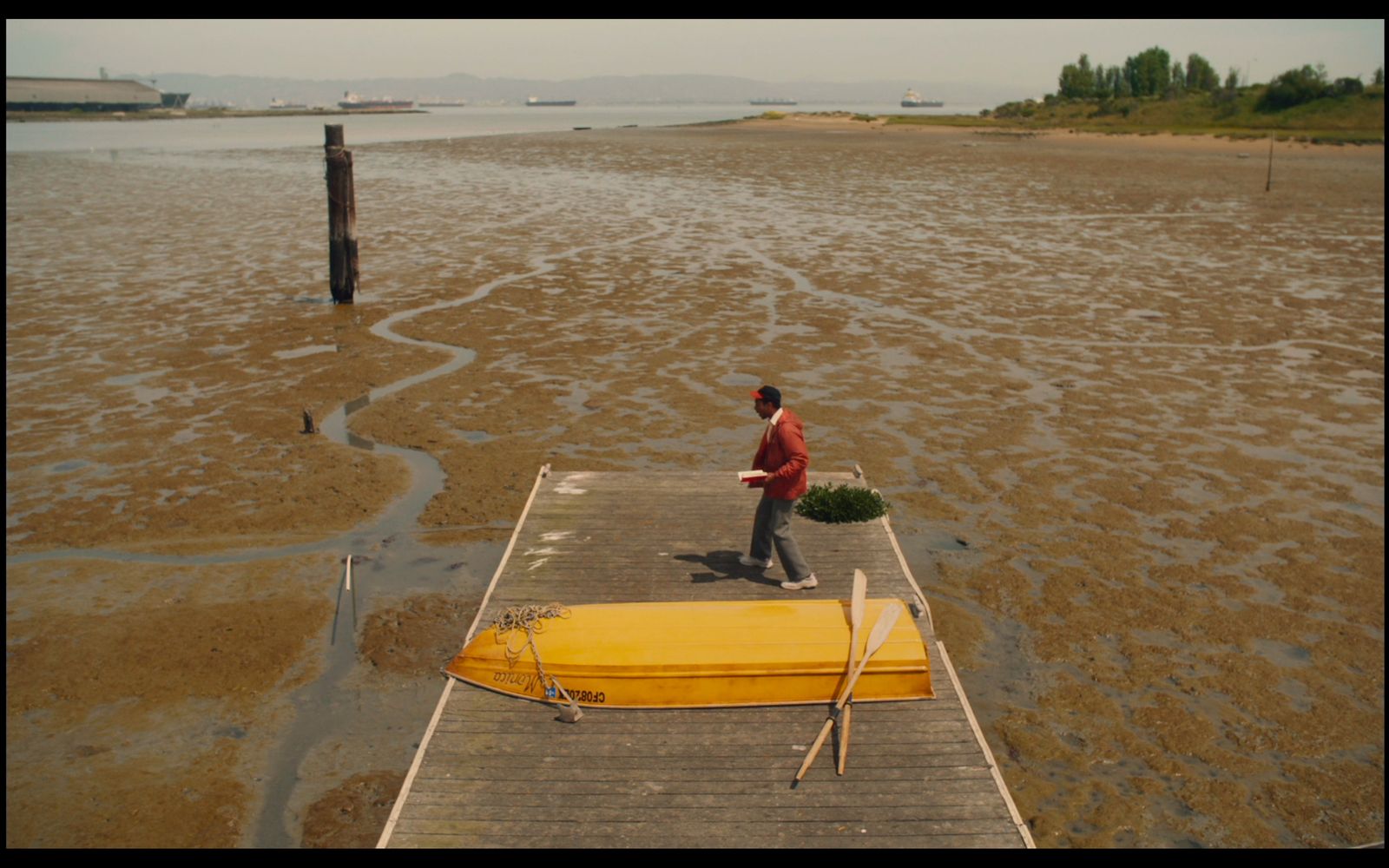 a man standing on a dock next to a yellow boat