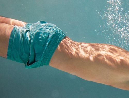 a man swimming under water in a pool