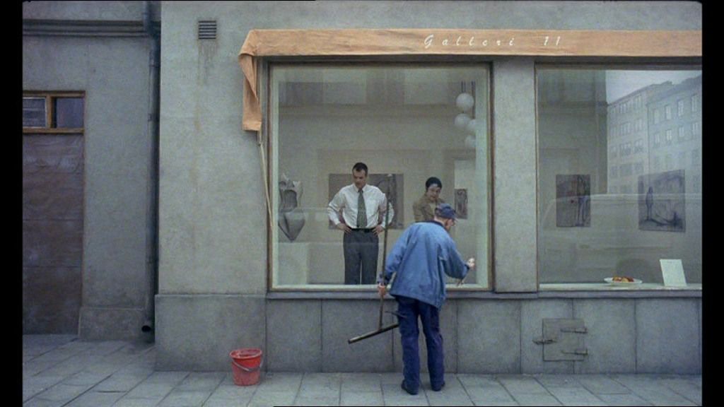 two men are standing outside of a store window