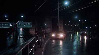 a couple of cars driving down a street at night