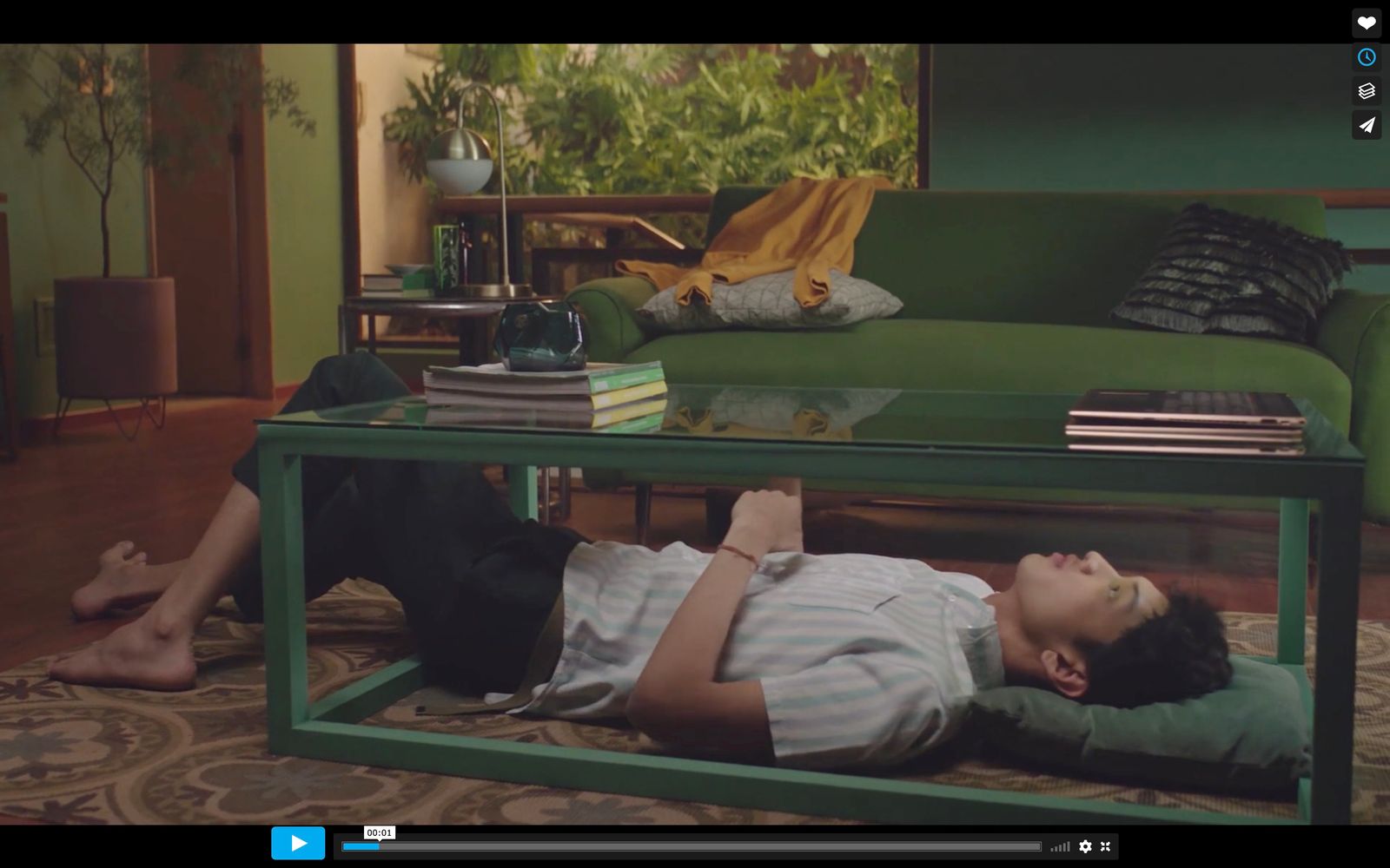 a man laying on the ground in front of a coffee table