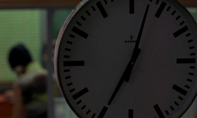 a close up of a clock with a person in the background