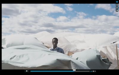 a man standing in front of a pile of pillows