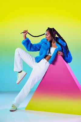 a woman sitting on top of a colorful object