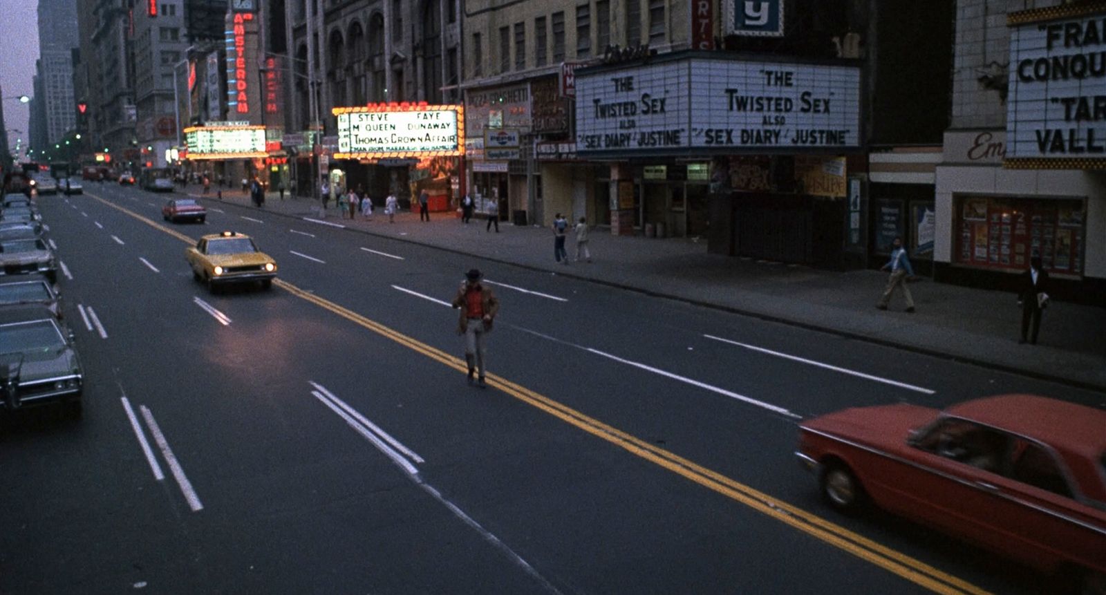 a man riding a bike down a street next to tall buildings