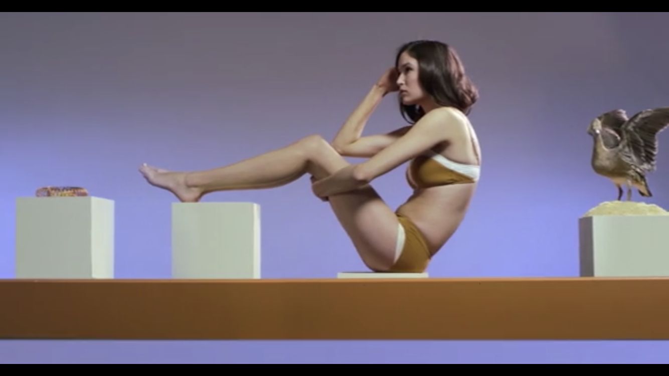 a woman in a bikini sitting on top of a table