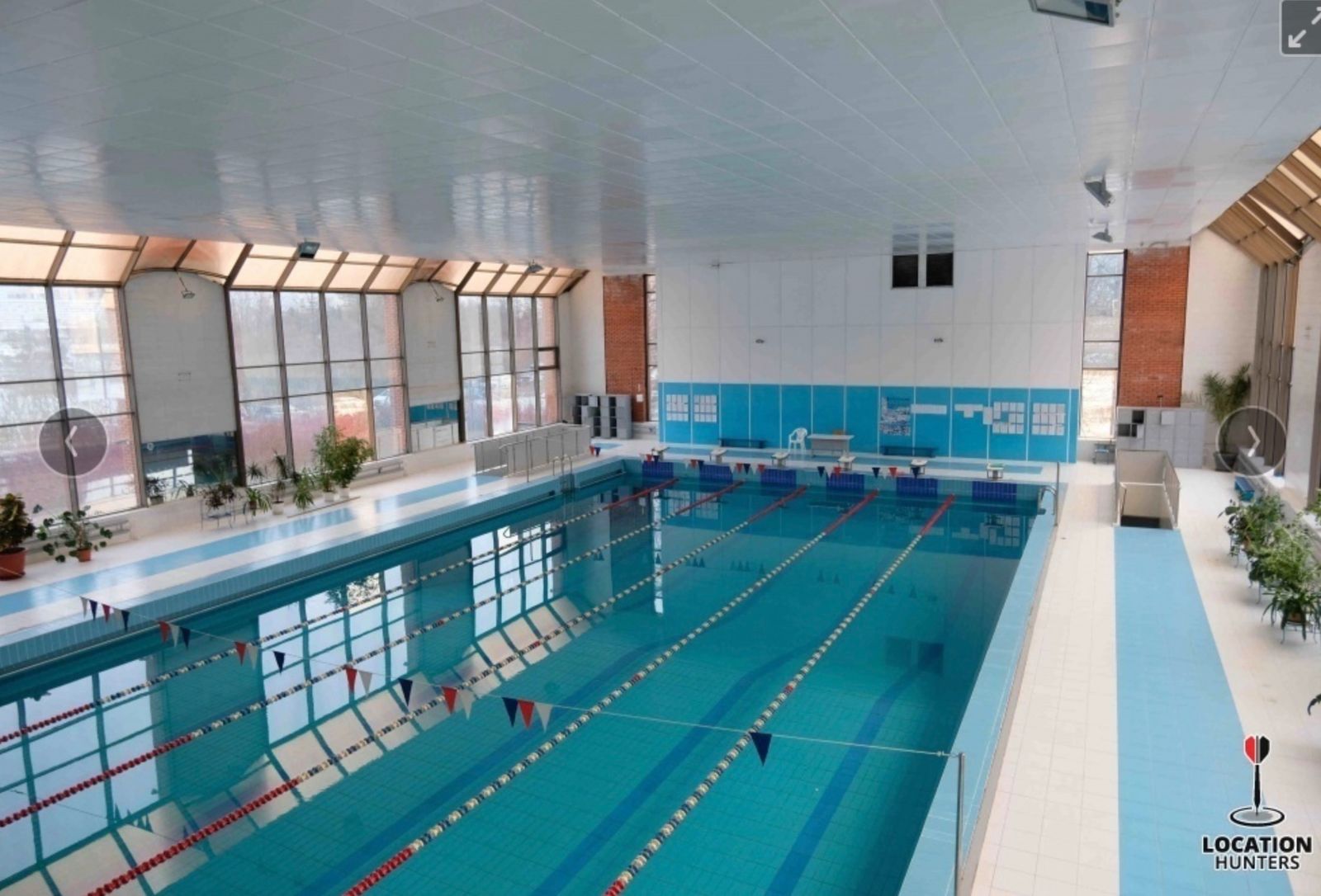 a large indoor swimming pool with blue walls