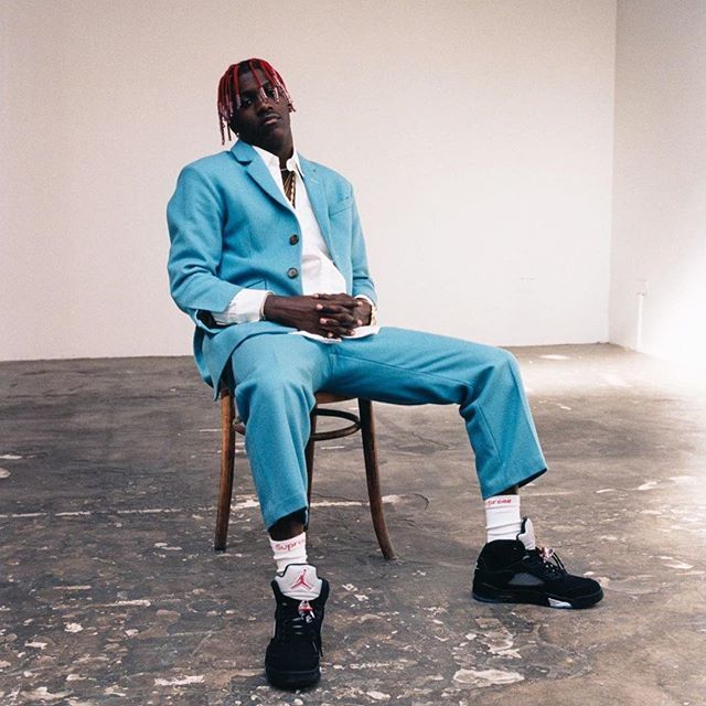 a man in a blue suit sitting on a chair