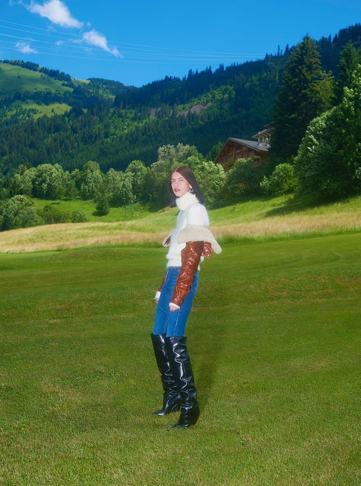 a woman standing on top of a lush green field