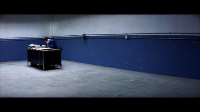 a man sitting at a desk in an empty room