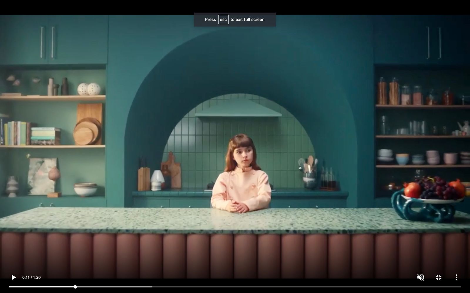 a girl sitting at a counter in a kitchen