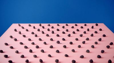 a pink surface with black dots on it