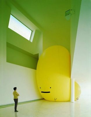 a man standing next to a giant yellow object